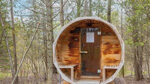 A wooden cabin with a curved entrance, a door, and a small window.