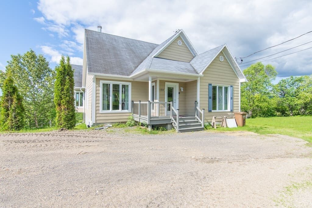 A two-story house with a front porch, a garage, and a driveway.