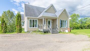 A two-story house with a front porch, a garage, and a driveway.