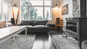 Una sala de estar acogedora con un sofá gris, una mesa de centro de madera y una chimenea.