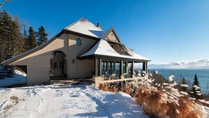 A house with a large deck and a view of the water.