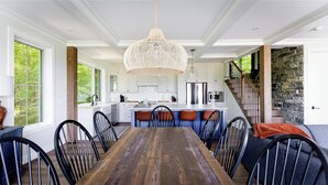 Una cocina moderna con gabinetes blancos, una isla central y una lámpara colgante.