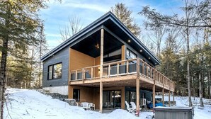 A modern cabin with a wooden deck and a covered outdoor area. - Hôtel à la maison - Chalet Kölega, spa et nature (Potton)