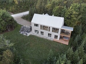 A modern two-story house with a large deck, surrounded by dense forest. - Hôtel à la maison - Bergen (Les Éboulements)