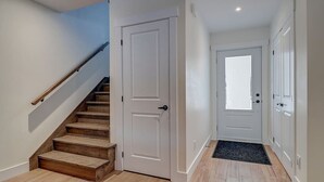 Un escalier avec des marches en bois menant à une porte blanche.
