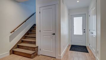 Un escalier avec des marches en bois menant à une porte blanche.