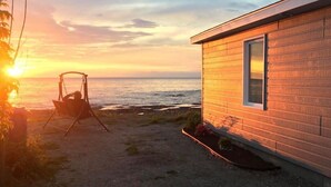 Een houten hutje met uitzicht op de oceaan tijdens de zonsondergang.