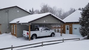 Eine Garage voller Schnee, in der ein weißer Pritschenwagen geparkt ist.
