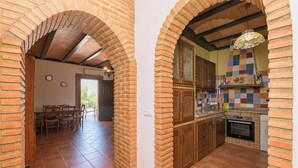 Une cuisine avec des murs en briques, des armoires en bois et un sol carrelé.