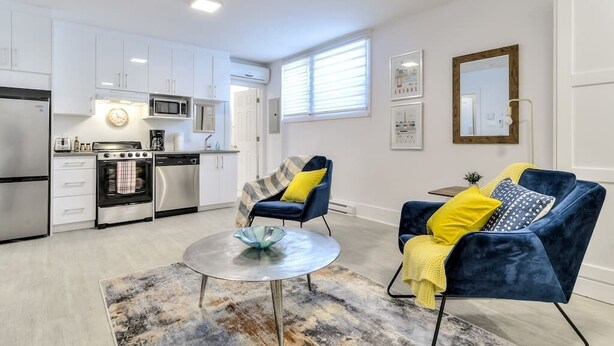 Un appartement moderne comprenant une cuisine, un coin repas et un salon.