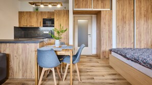 Un apartament modern amb cuina, zona de menjador i zona de dormir.