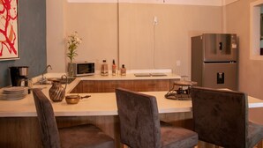 A modern kitchen with a central island, stainless steel appliances, and a chandelier. - Antique Hotel (Mexico City)