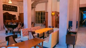 A spacious lobby with a central seating area, a dining table, and a piano. - Antique Hotel (Mexico City)