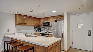 A modern kitchen with wooden cabinets, stainless steel appliances, and a white countertop. - Lodge at Mtn Village B261 | Ski-In/Out | Plaza View | PCMR | Pool | Hot Tub (Park City)