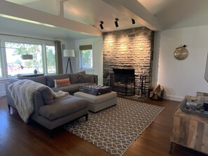 Cozy up by the fireplace in this inviting living room, featuring a plush sofa and a stylish rug.