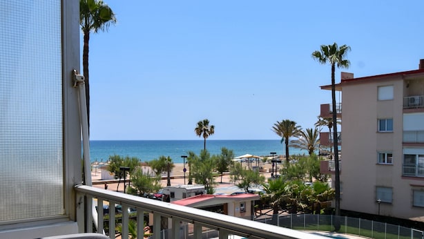A balcony with a view of a swimming pool, palm trees, and a beach. - Ref: 278  Beach apartment with pool and parking (Fuengirola)