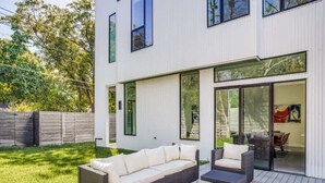 Une maison moderne dotée d’un patio aménagé avec un ensemble de canapés et une table basse.
