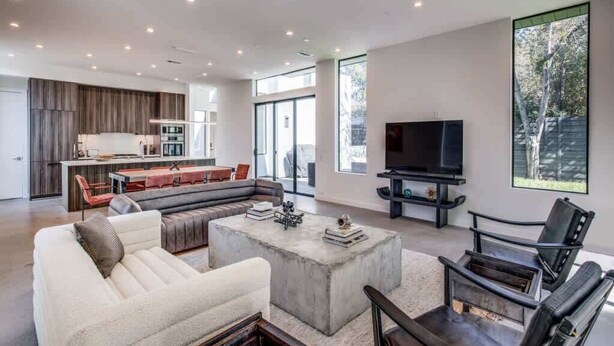 Un salon moderne avec un canapé, une table basse et un meuble pour la télévision.