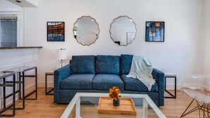 A living room with a sofa, coffee table, and artwork on the wall.