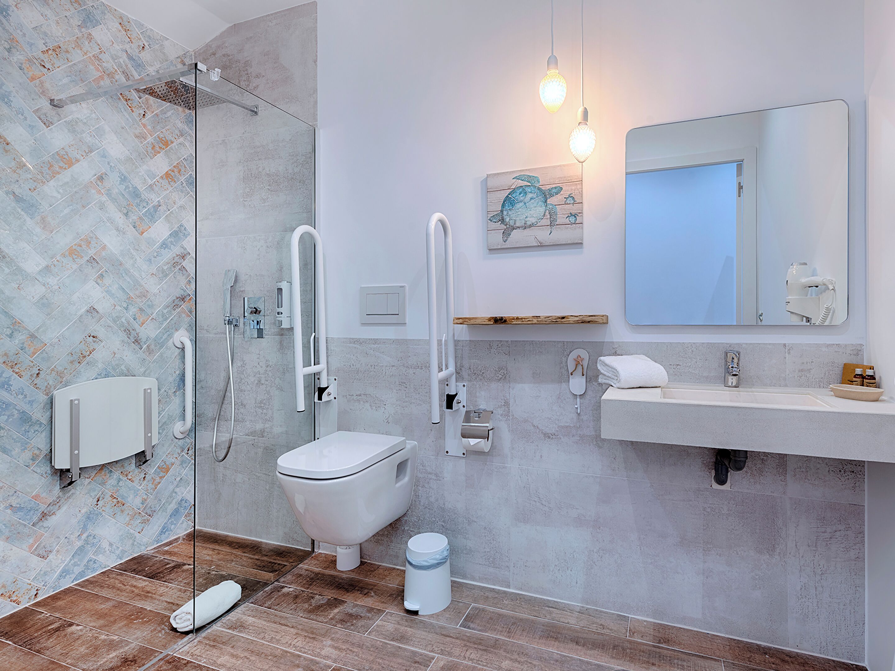 Un baño moderno con ducha, inodoro y lavamanos, que presenta un patrón de baldosas en espiga y un estante de madera.