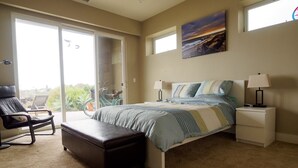 Une chambre à coucher avec un lit, une table de chevet, une chaise et une fenêtre donnant sur un beau paysage.