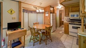 Eine kleine Küche mit Holzausstattung, inklusive Kühlschrank, Mikrowelle und Herd.