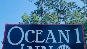 A sign for Ocean 1 Inn with a shell logo. - Ocean One Inn (Sneads Ferry)