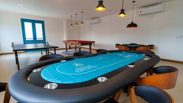 A pool table with a blue felt surface and a pool cue rack.