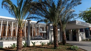 A building with a white facade, large windows, and a covered entrance area. - Resende Imperial Hotel &Spa (Itacaré)