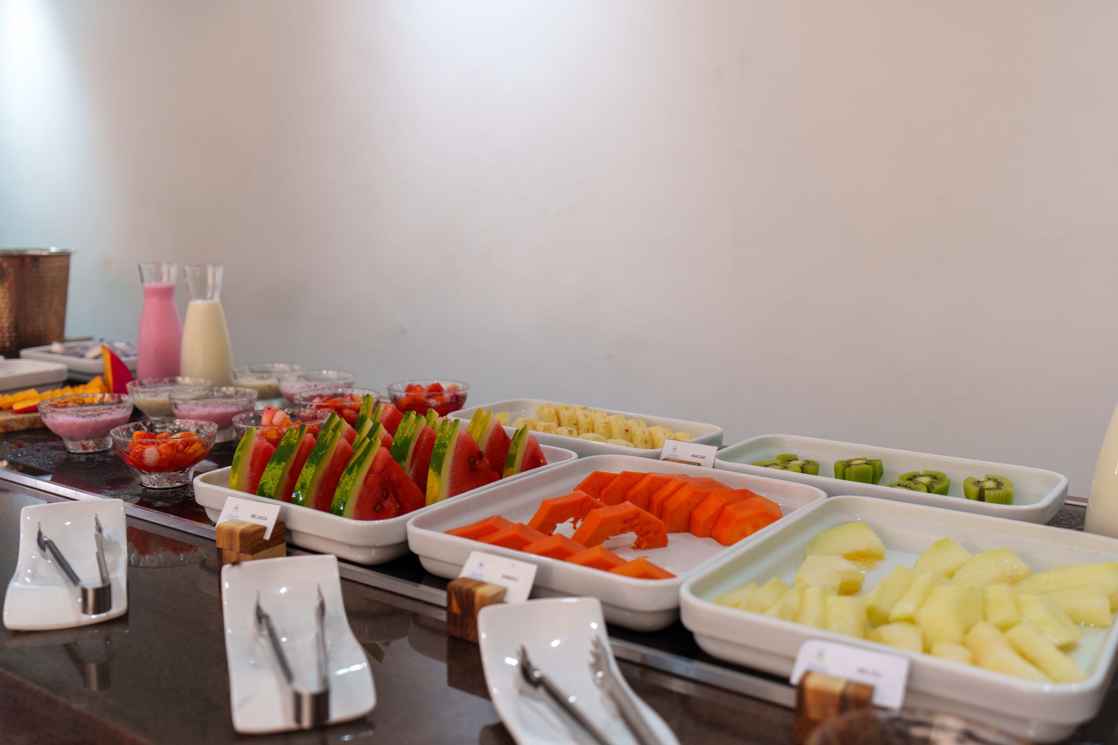 A buffet with various fruits and vegetables, including watermelon, pineapple, and kiwi.