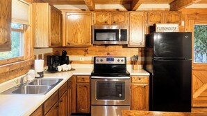 A kitchen with wooden cabinets, stainless steel appliances, a sink, and a sign that reads 'FARMHOUSE.' - 4 Br-Minutes to National Park!Enjoy the Farm Life! (Cosby)