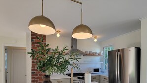 Una cocina moderna con una isla central, electrodomésticos de acero inoxidable y una pared de ladrillo decorativa.