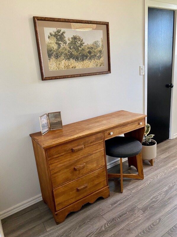 A wooden desk with drawers, a cushioned chair, and a framed picture on the wall. - Cottage #5 - 1 bedroom - pet friendly! (French River)
