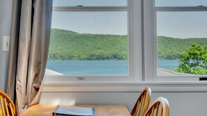 A room with a table and chairs, a window with a view of a lake and hills. - 3 Bedroom Cottage only 10 minutes from Cooperstown (Cooperstown)