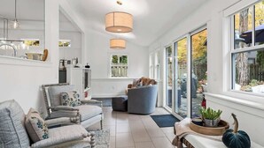 A spacious living room with a large window, a fireplace, and a cozy seating area.