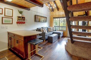 A cozy interior with a wooden staircase, a kitchen area, and a seating space. - Cozy Brianhead Condo: Easy Walk to Giant Steps (Brian Head)