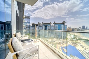 Un balcón con vistas a un paisaje urbano y una zona de piscina.