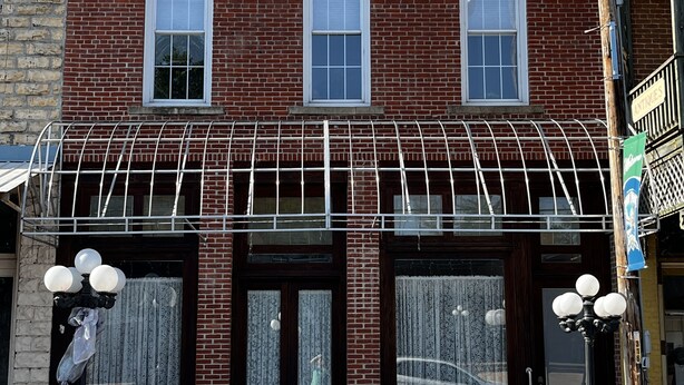 A brick building with a storefront and three windows.