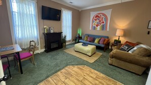A living room with a fireplace, a sofa, a coffee table, and a television.