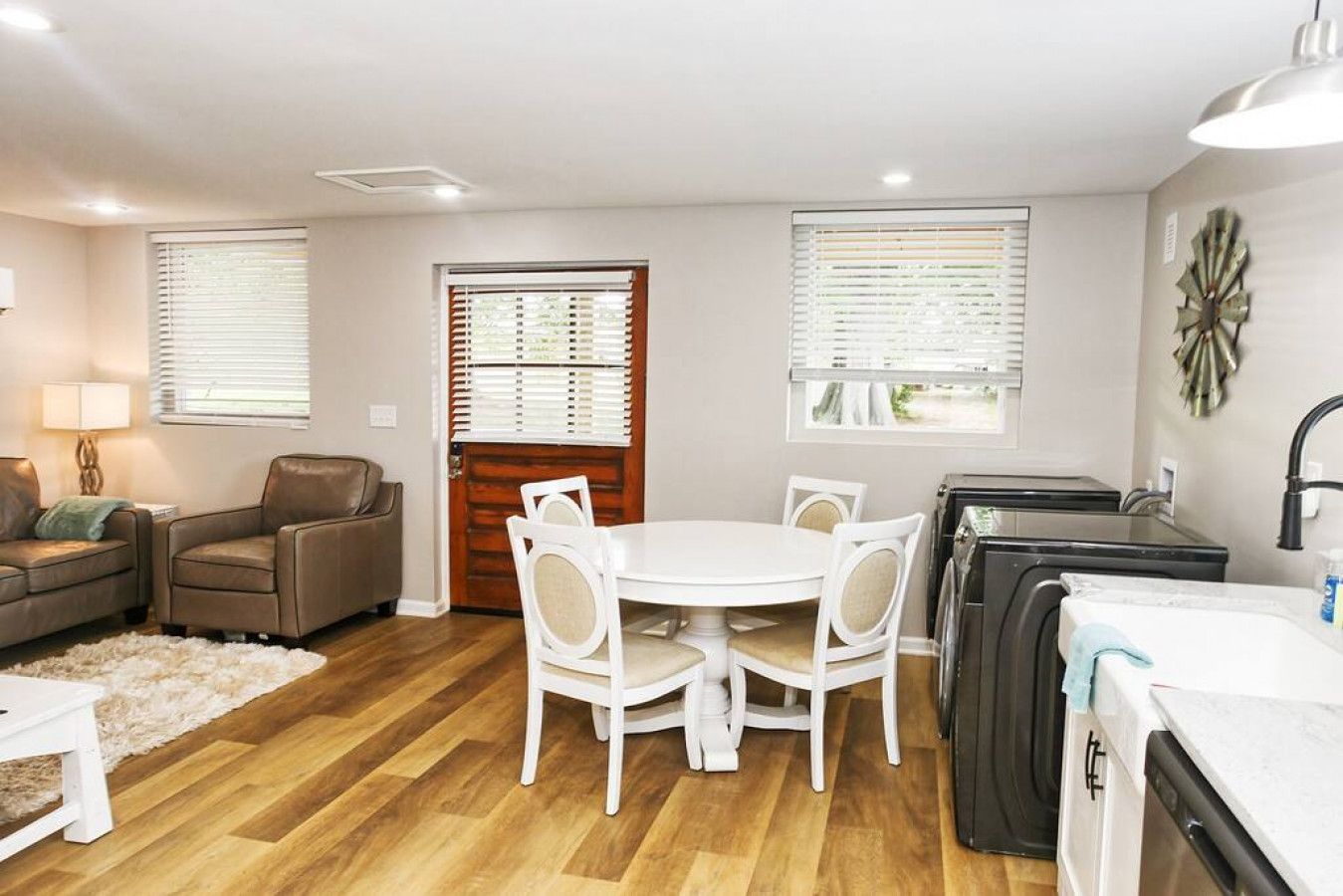 Un espacio habitable compacto con comedor, sofá, mesa de centro y kitchenette.