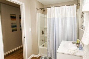Une salle de bain équipée d’une douche, d’une baignoire et d’un lavabo avec des articles de toilette.
