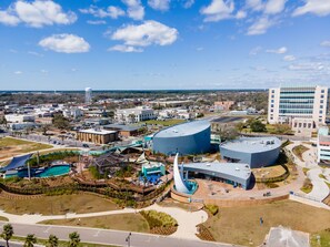 Luchtbeeld van een stadsgezicht met een groot aquarium, een opvallend blauw gebouw en een parkeerterrein.