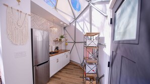Una cocina moderna con refrigerador de acero inoxidable, encimera de madera y salpicadero con motivo de espiga.
