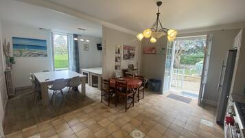 Una cocina amplia con comedor, ventanas grandes y vistas al exterior.