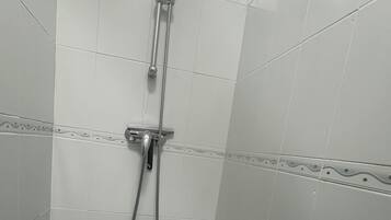 A shower with a handheld showerhead and a fixed showerhead.