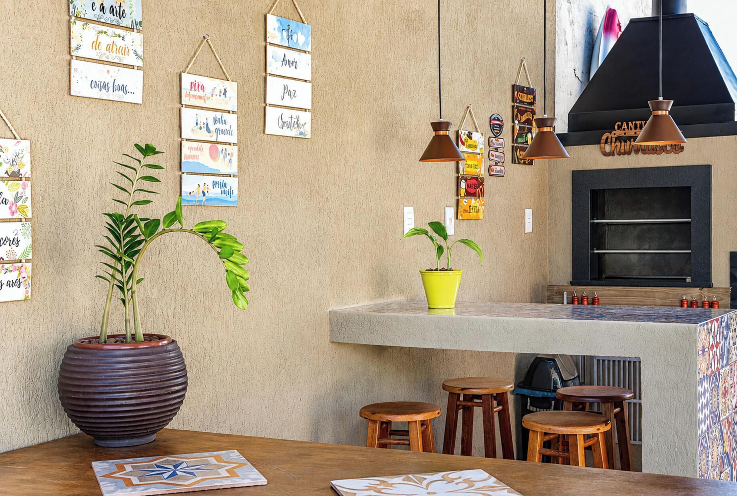 A kitchen with a built-in oven, hanging pendant lights, and a potted plant on the counter.