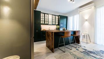 Una cucina moderna con mobili scuri, un'isola in legno e un angolo bar con sgabelli.