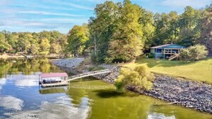 A lakeside property with a dock, a bridge, and a house surrounded by trees. - Kerr Contentment   Kerr Lake/Buggs Island waterfront, an amazing view (Clarksville)