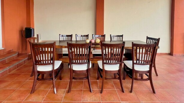 A conference room with a large table and six chairs, a speaker, and a staircase leading to an upper level. - Rancho Chanel (Santa Ana)