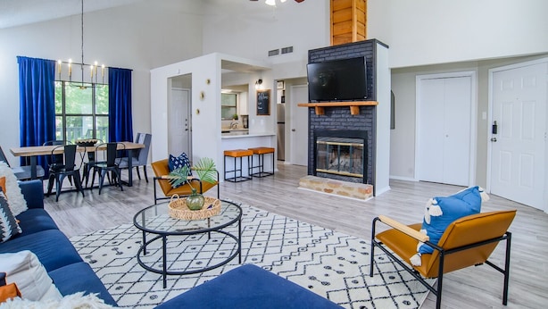 Amplia sala de estar con chimenea, comedor y cocina.